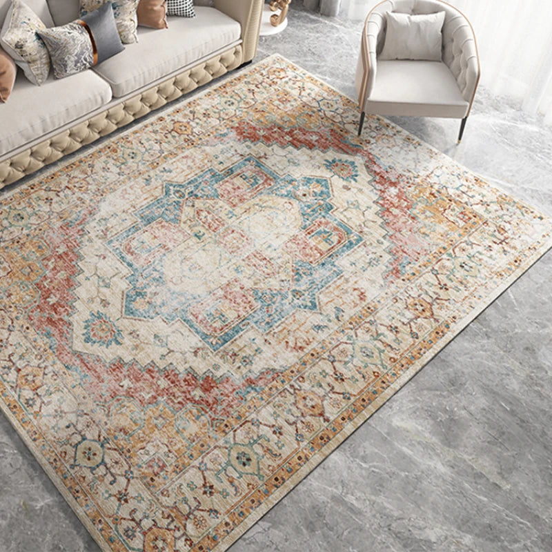 Tapis à motif géométrique rétro pour salon Nesty - Motif médaillon bohème bleu, rouge et orange dans un salon beige