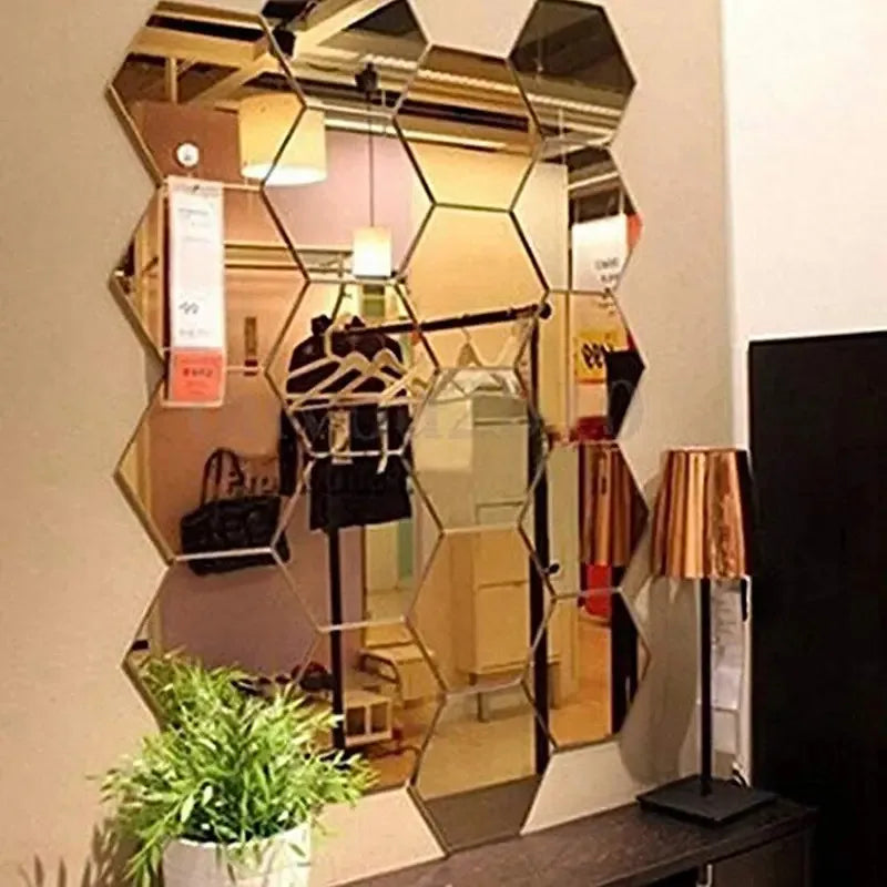 Stickers muraux miroir hexagonaux — set autocollant - Nesty, stickers miroir hexagonaux dorés assemblés sur un mur, reflet d'un intérieur de boutique avec portant à vêtements