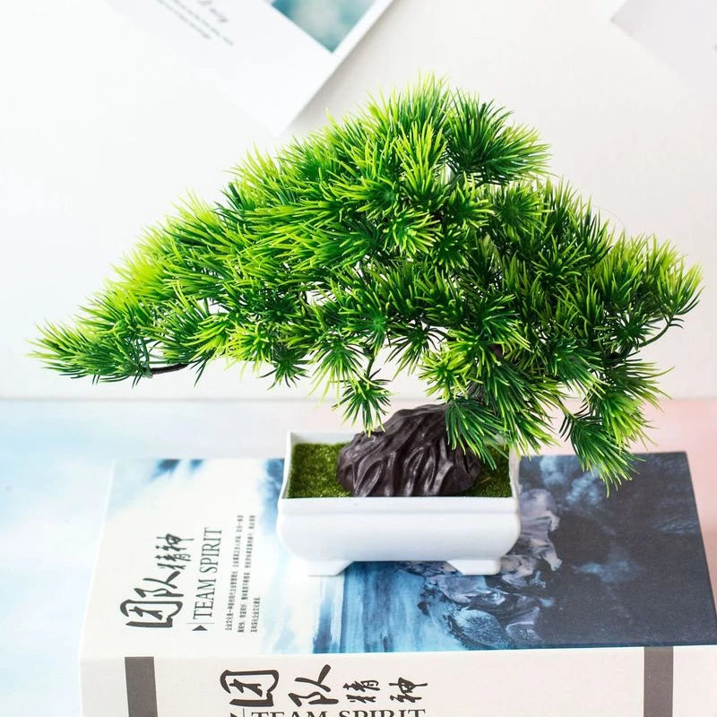 Bonsaï artificiel en pot Nesty - Modèle pin, posé sur un livre