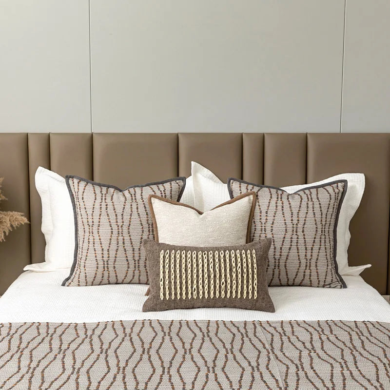 Housse de coussin en coton et lin beige, bordure texturée Nesty, parure de lit avec housses de coussin à motif de lignes ondulées brunes sur fond beige, bordure grise, sur tête de lit capitonnée marron