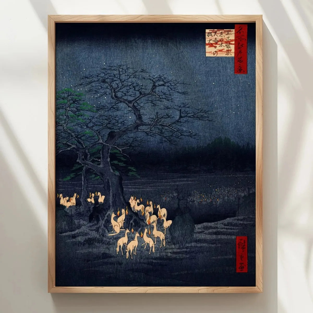 Toile imprimée renard japonais Nesty - Affiche encadrée en bois clair accrochée sur un mur clair, lumière douce