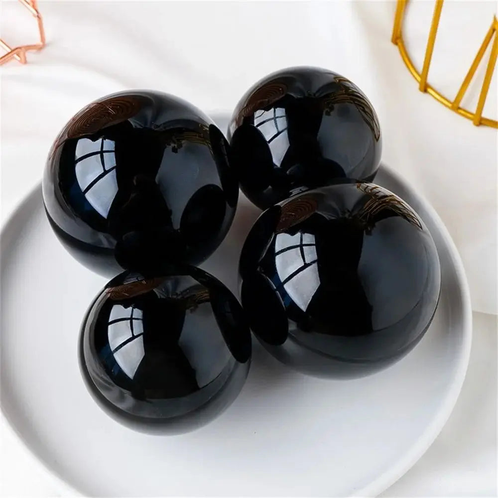 Sphère en obsidienne naturelle Nesty - Quatre sphères présentées sur une assiette