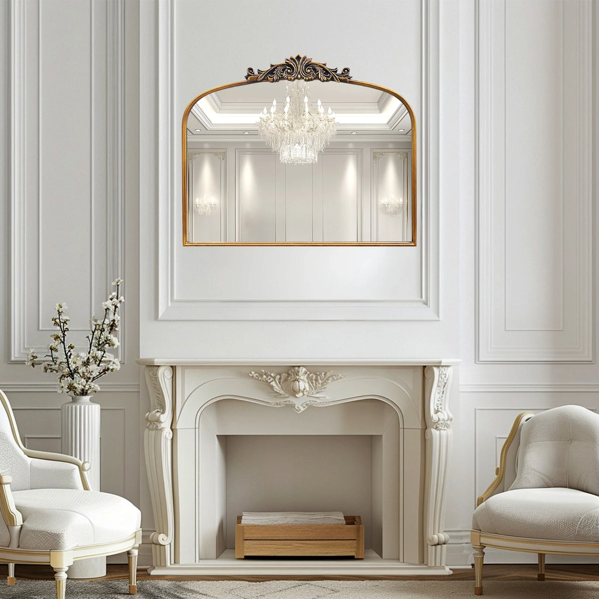 Miroir baroque cintré — relief doré - Nesty, accroché au-dessus d'une cheminée blanche ornée entre deux fauteuils crème et un bouquet de fleurs de cerisier