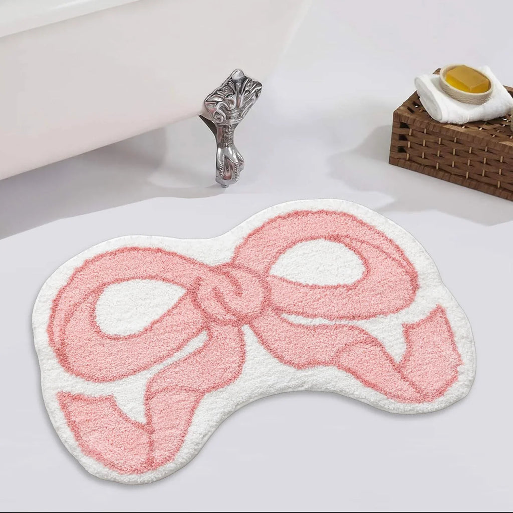 Petit tapis à motif nœud — imitation cachemire - Nesty, variante rose posée au sol d'une salle de bain au pied d'une baignoire à pieds griffus