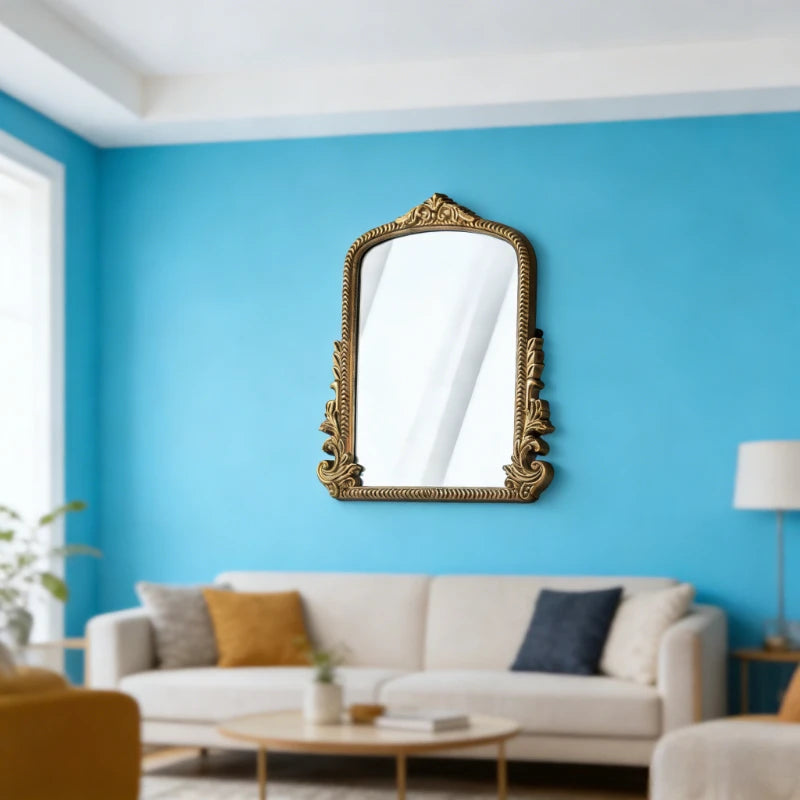 Miroir de coiffeuse doré — cadre en bois ancien - Nesty, accroché sur un mur bleu au-dessus d'un canapé beige avec coussins moutarde et bleu marine