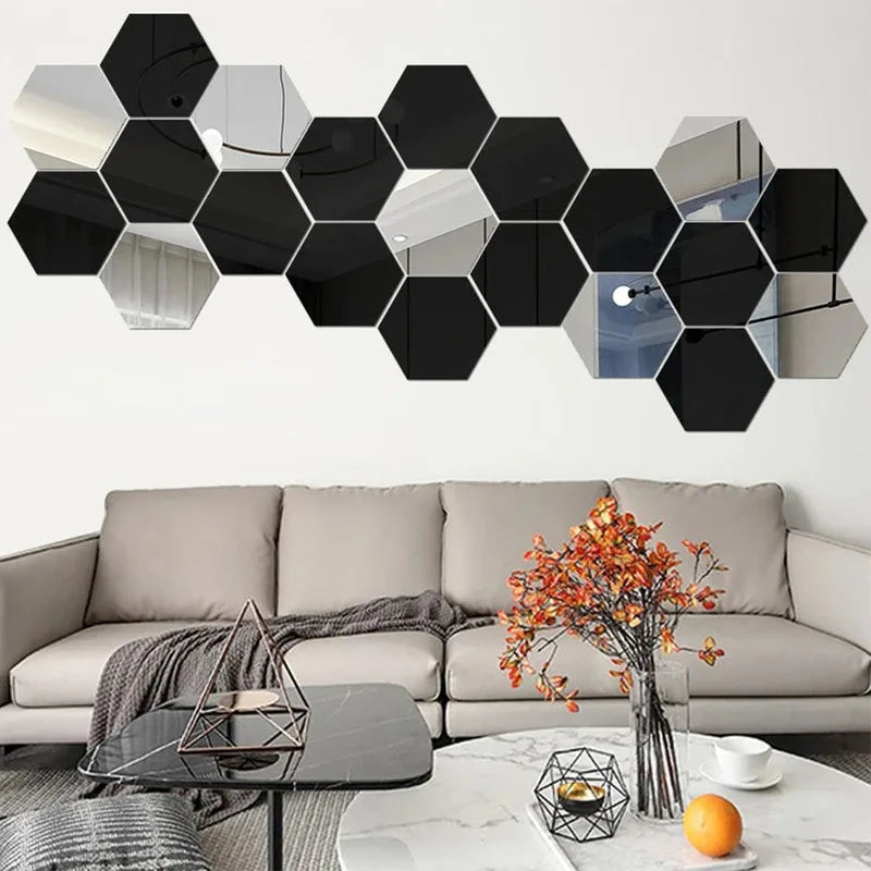 Stickers muraux miroir hexagonaux — set autocollant - Nesty, variante noire disposée au-dessus d'un canapé beige avec bouquet de feuillage automnal