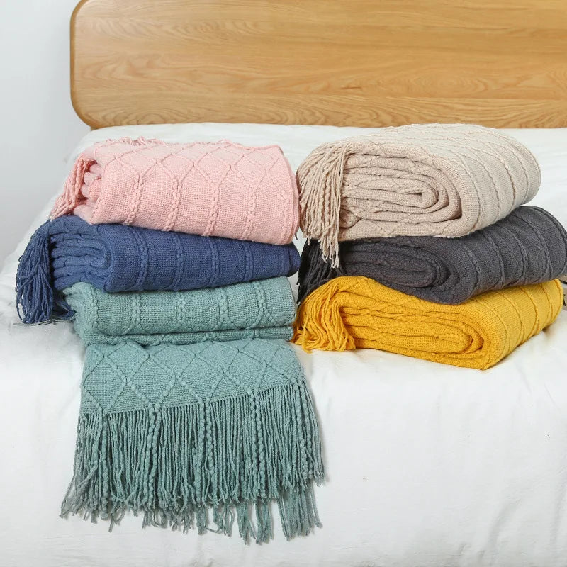 Plaid oversize tricoté Nesty - Gamme complete de coloris pliés sur lit, rose, bleu marine, vert sauge, beige, gris et jaune