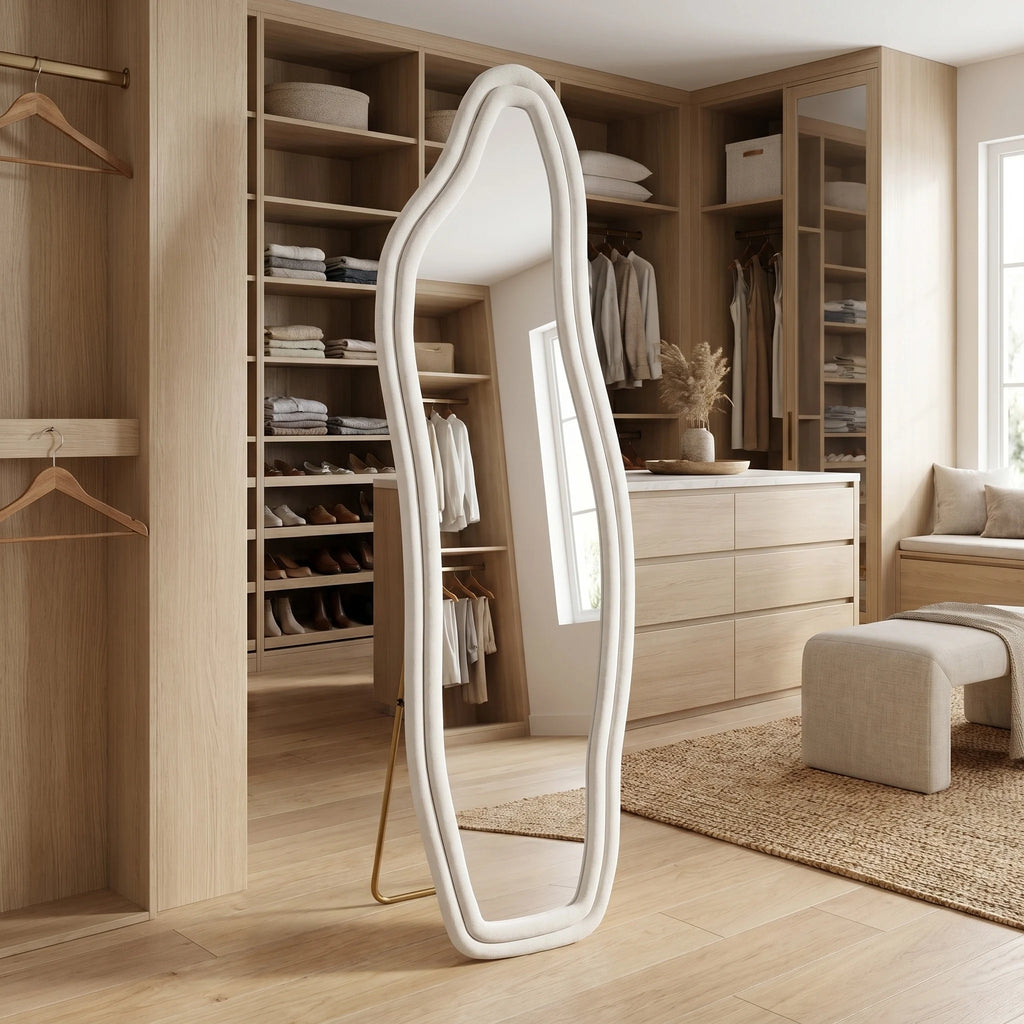Grand miroir sur pied forme organique ondulée, cadre velours ivoire, dans un dressing en bois clair - Nesty