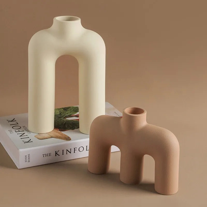 Vase en céramique au design sculptural, style moderne épuré Nesty, deux vases arqués mats crème et terracotta, posés sur un livre The Kinfolk Garden