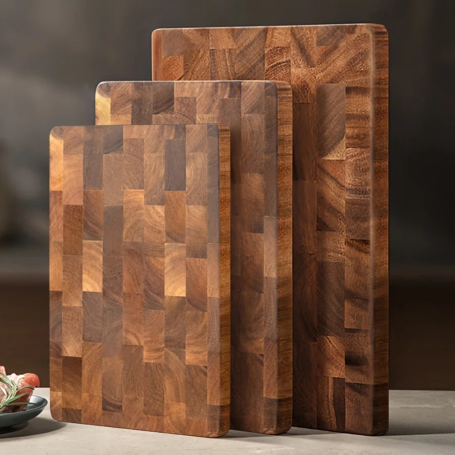 Grande planche à découper en bois massif à grain apparent Nesty, trois tailles de planches à grain de bout apparent, debout sur un plan de travail, fond sombre