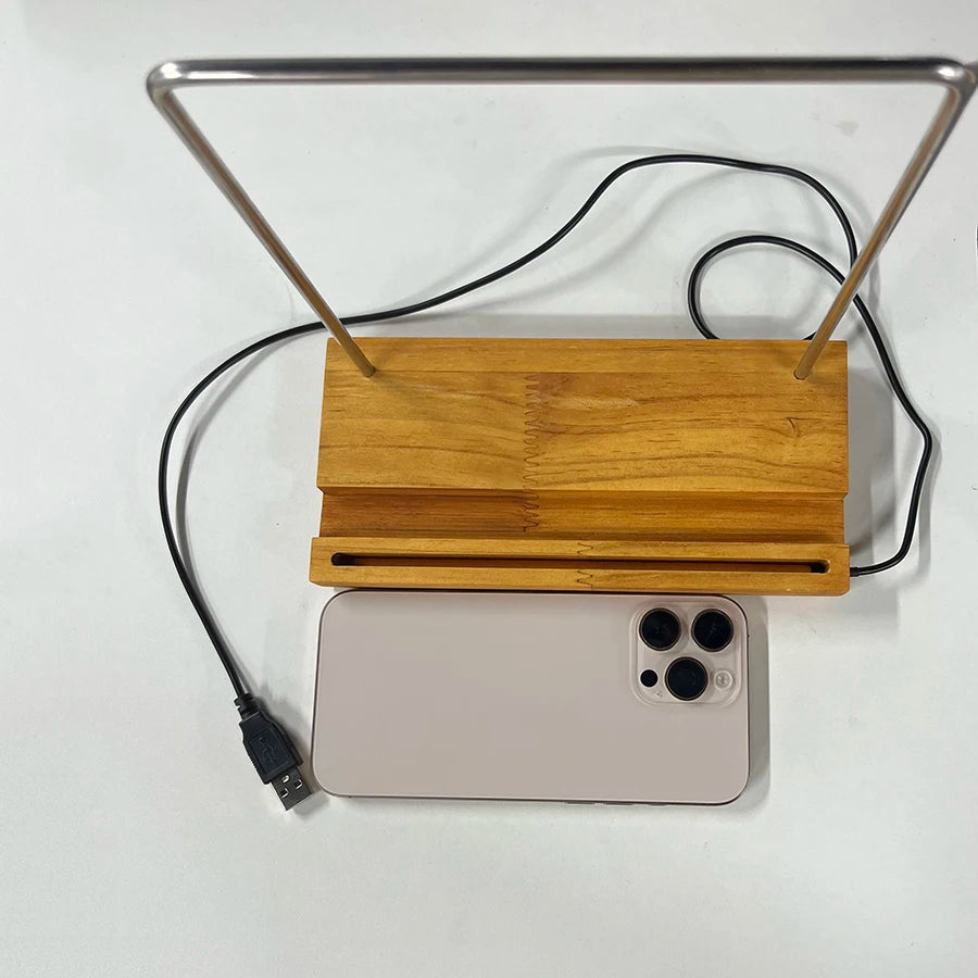 Support lumineux pour vinyle Nesty - Vue du dessus du socle en bois avec câble USB et smartphone pour comparaison de taille