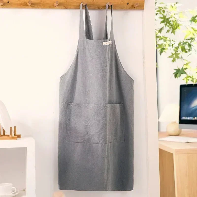Tablier en lin gris suspendu à une patère en bois, style japonais épuré, devant une fenêtre - Nesty
