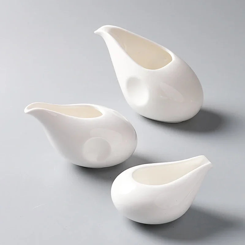 Petit pot à lait en céramique blanche avec anse Nesty, trois tailles en forme de goutte blanche, posées sur fond gris