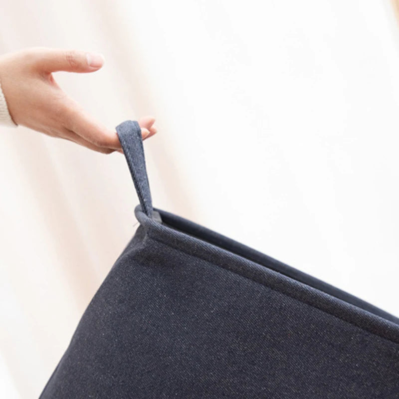Panier à linge pliable en toile de jute Nesty - Gros plan sur l'anse tenue à la main