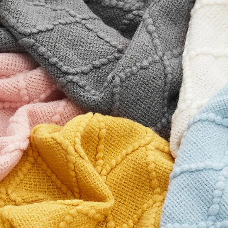 Plaid oversize tricoté moelleux Nesty - Gros plan sur six coloris gris, rose, jaune, blanc et bleu ciel côte à côte
