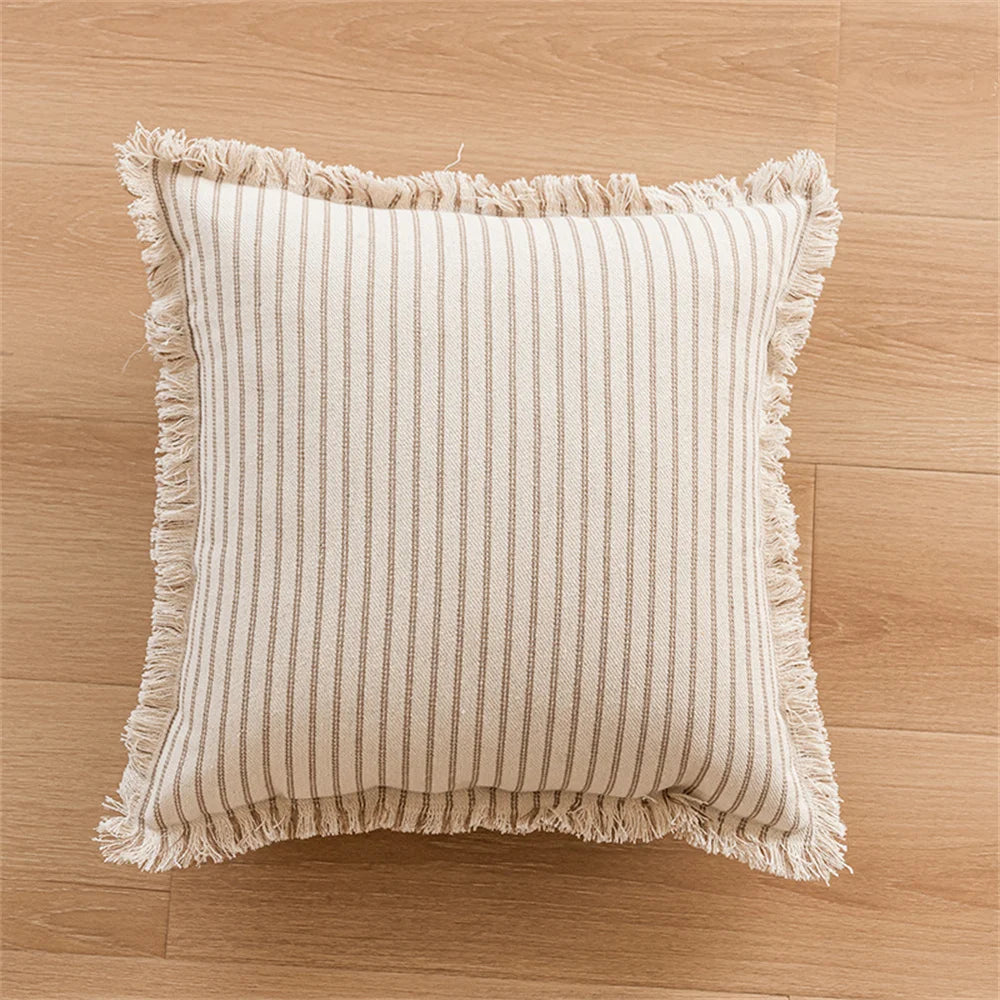 Housse de coussin en lin à rayures, plusieurs formats disponibles Nesty, housse de coussin carrée à rayures beige et brun avec bordure à franges, vue de dessus sur parquet