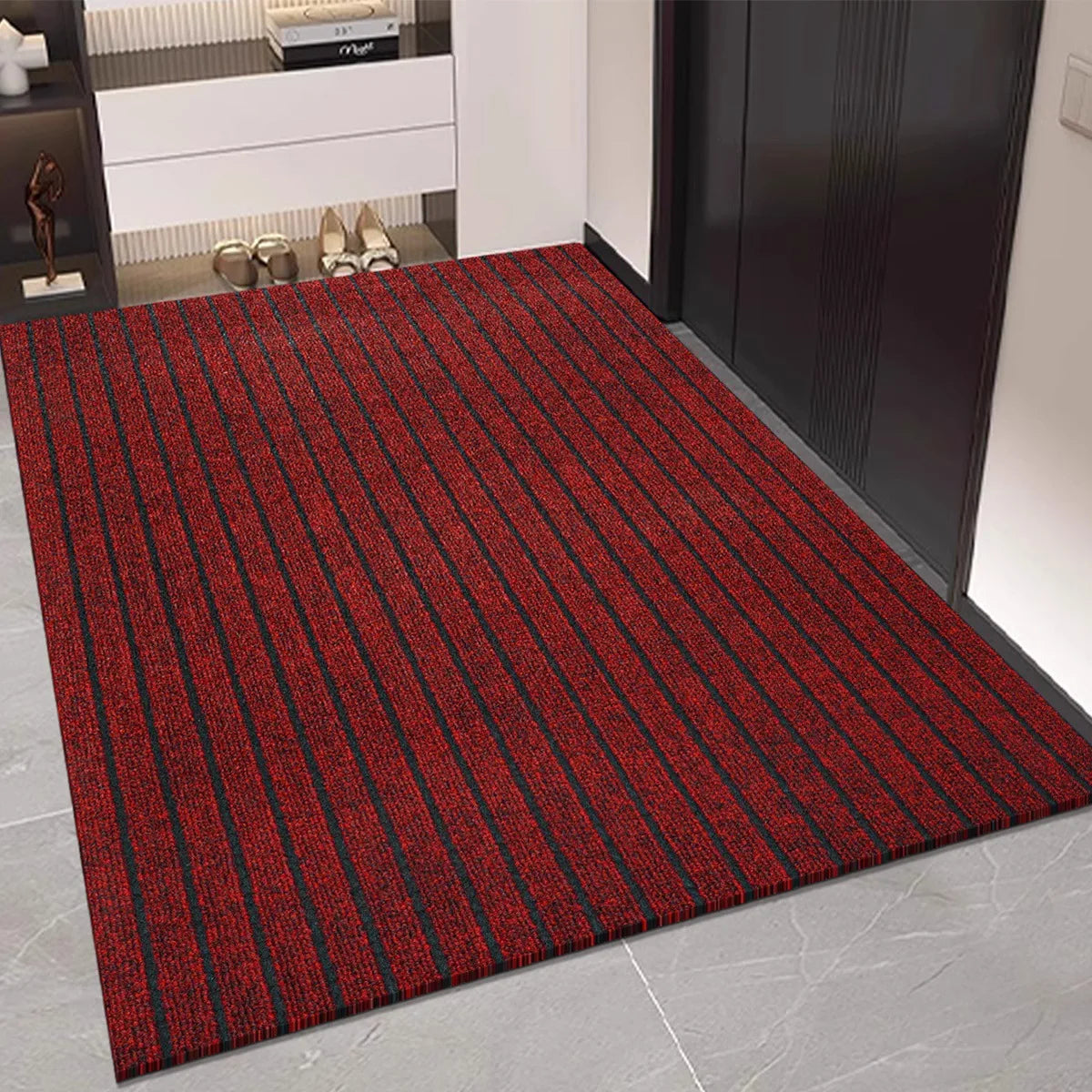 Tapis de cuisine en rouleau à rayures - Nesty, variante rouge et noire à rayures posée dans une entrée près d'un meuble à chaussures