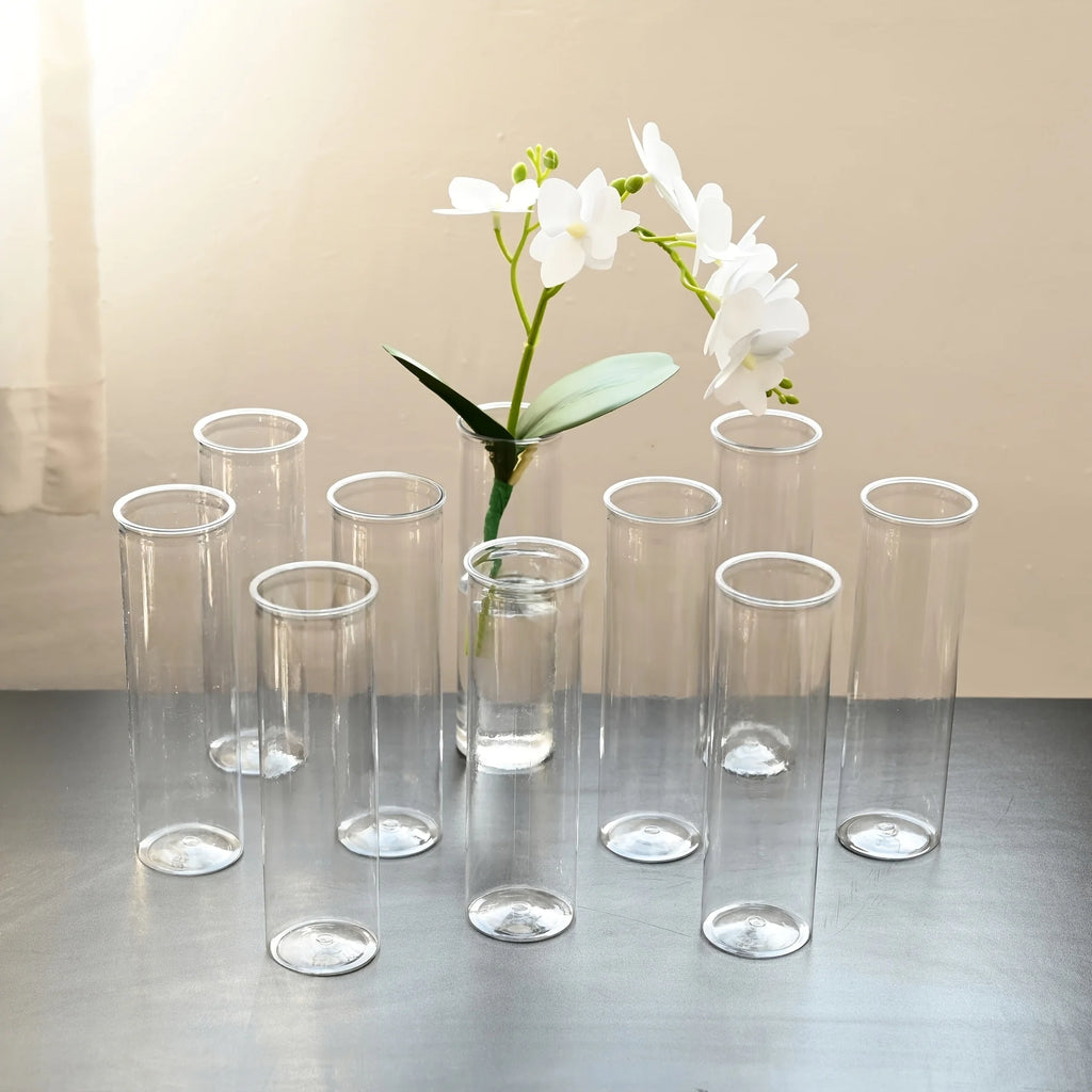 Set de vases cylindriques transparents, trois tailles - Nesty - Neuf vases cylindriques en verre transparent de tailles variées, l'un garni d'une orchidée blanche, sur une table grise