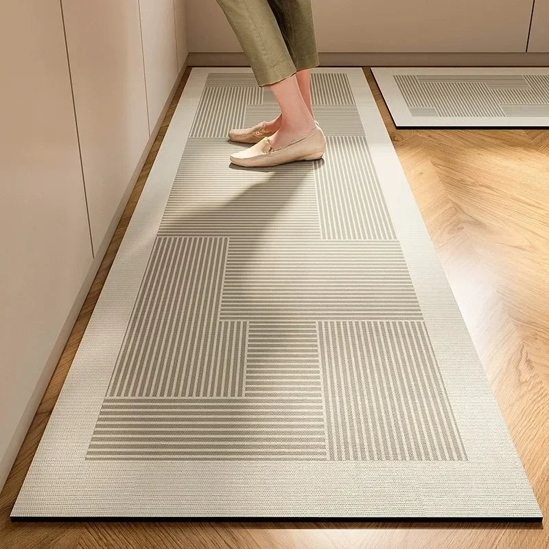 Tapis de cuisine en diatomée — disponible en lot - Nesty, chemin de cuisine gris et blanc à motif géométrique en blocs, pieds visibles à l'entrée d'une cuisine