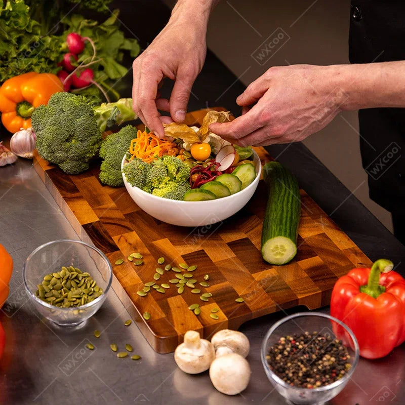 Planche à découper en bois double face, pour légumes et viande Nesty, en situation, mains d'un chef garnissant un bol de salade de brocoli et concombre sur la planche