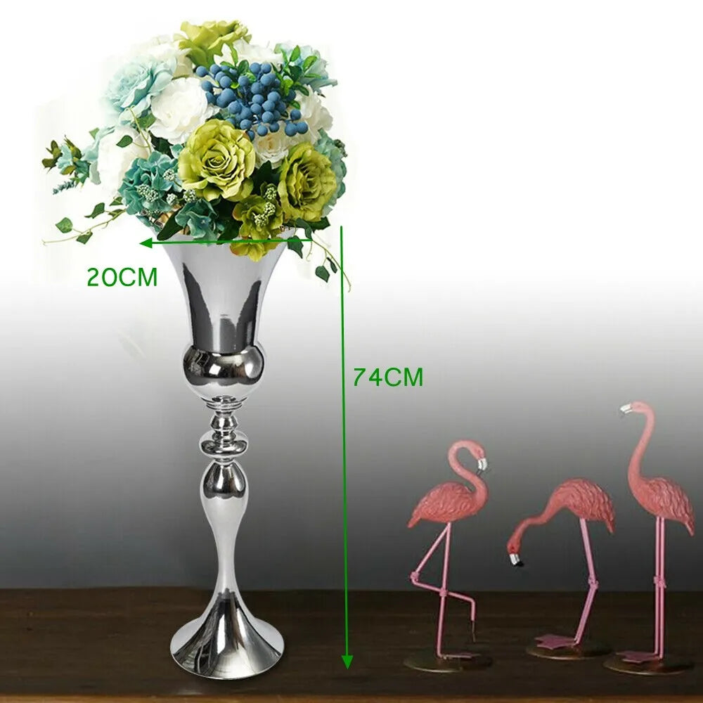 Vase en métal finition dorée, design élégant - Nesty - Vase sur pied en métal argenté garni d'un bouquet de roses vertes et blanches, avec cotations 20cm et 74cm, figurines de flamants roses à côté