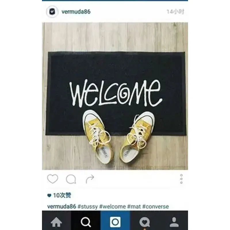 Tapis d'entrée en PVC à motif graphique Nesty - Message Welcome, avec une paire de baskets jaunes posées dessus