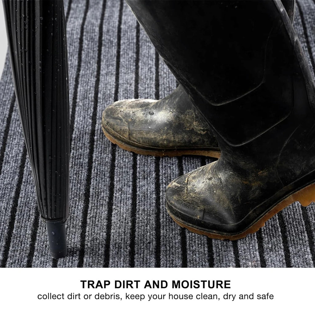 Tapis long à rayures — cuisine et entrée - Nesty, gros plan sur des bottes en caoutchouc boueuses posées sur le tapis à rayures, mention piège à saleté et humidité