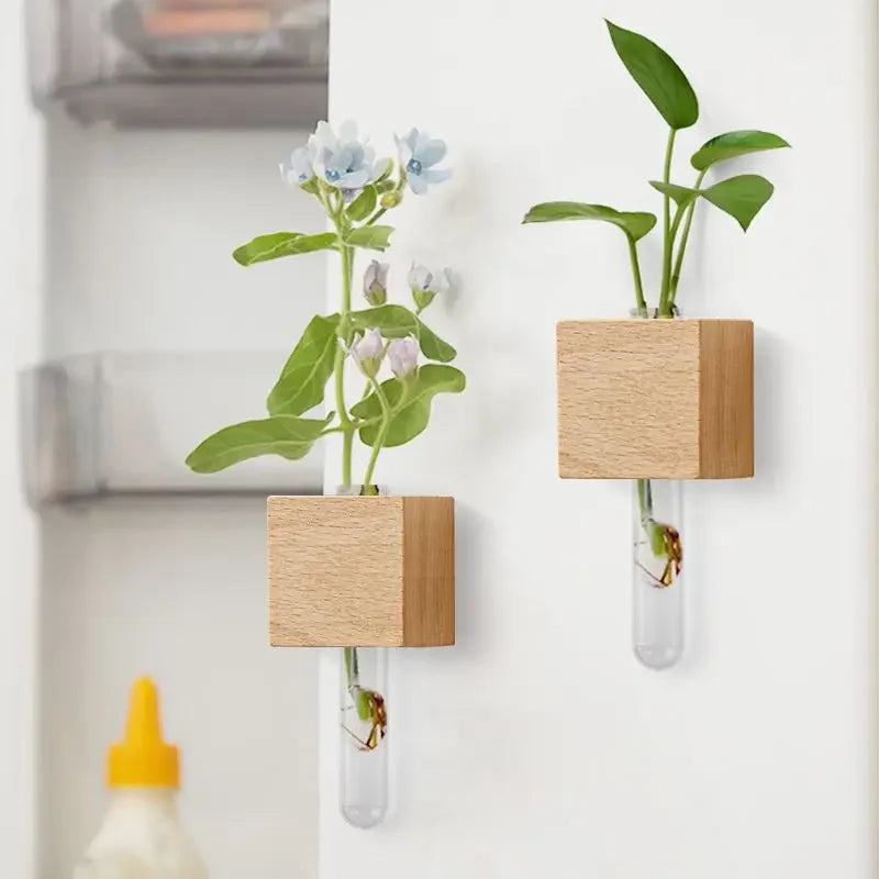 Mini vase tube aimanté en bois Nesty - Deux modèles fixés au mur avec fleurs bleues et pothos, près d'un frigo