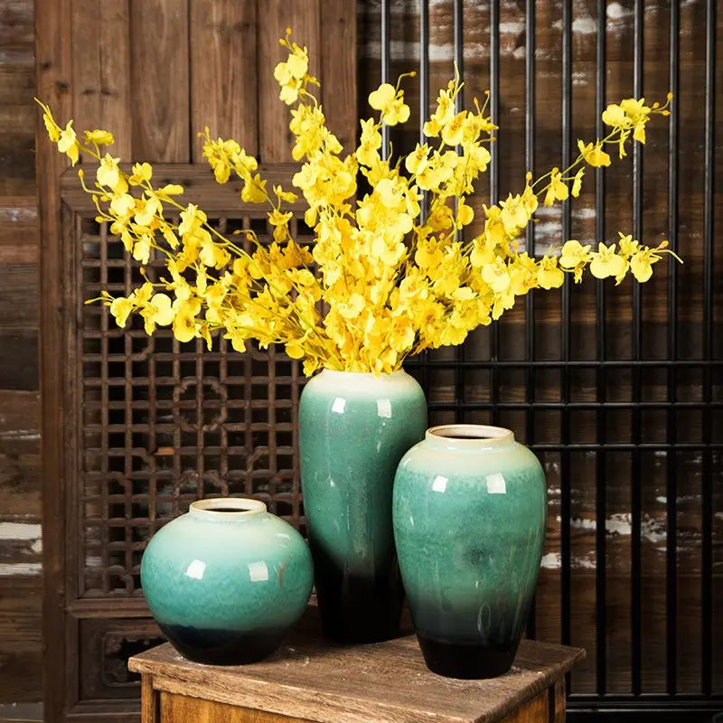 Grand vase en céramique, style rétro pour fleurs séchées Nesty, trois vases en céramique émaillée turquoise et noir de tailles différentes, garnis de fleurs jaunes, sur table en bois devant claustra