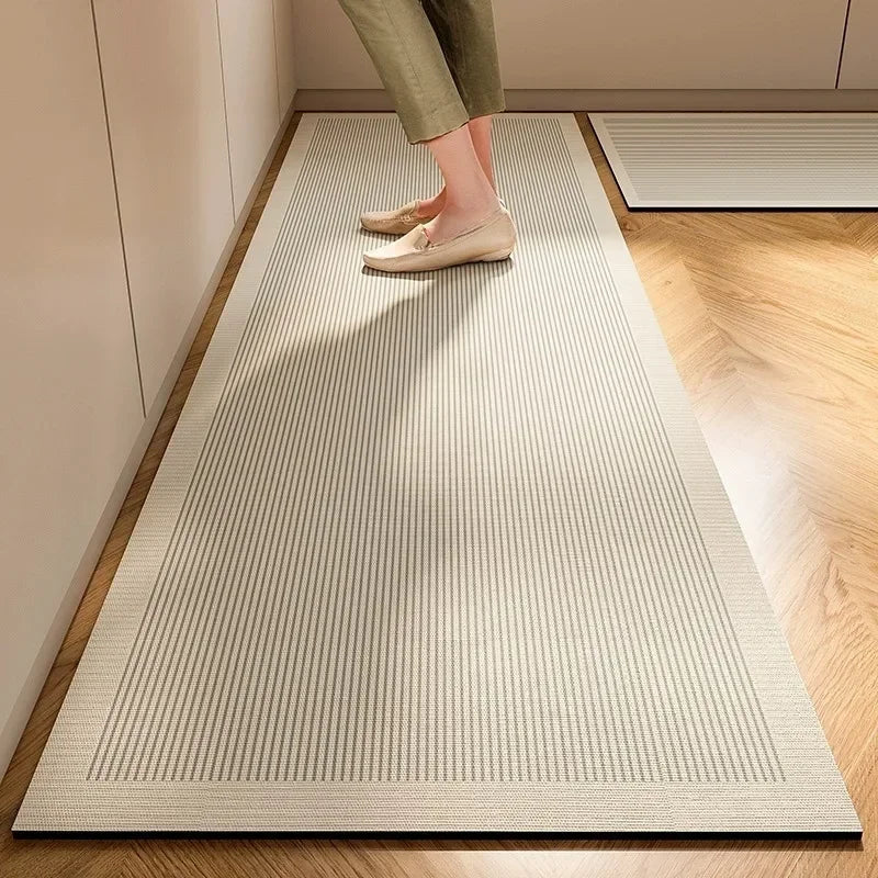 Tapis de cuisine en diatomée — disponible en lot - Nesty, variante à rayures verticales gris et blanc, pieds visibles, autre tapis assorti en arrière-plan