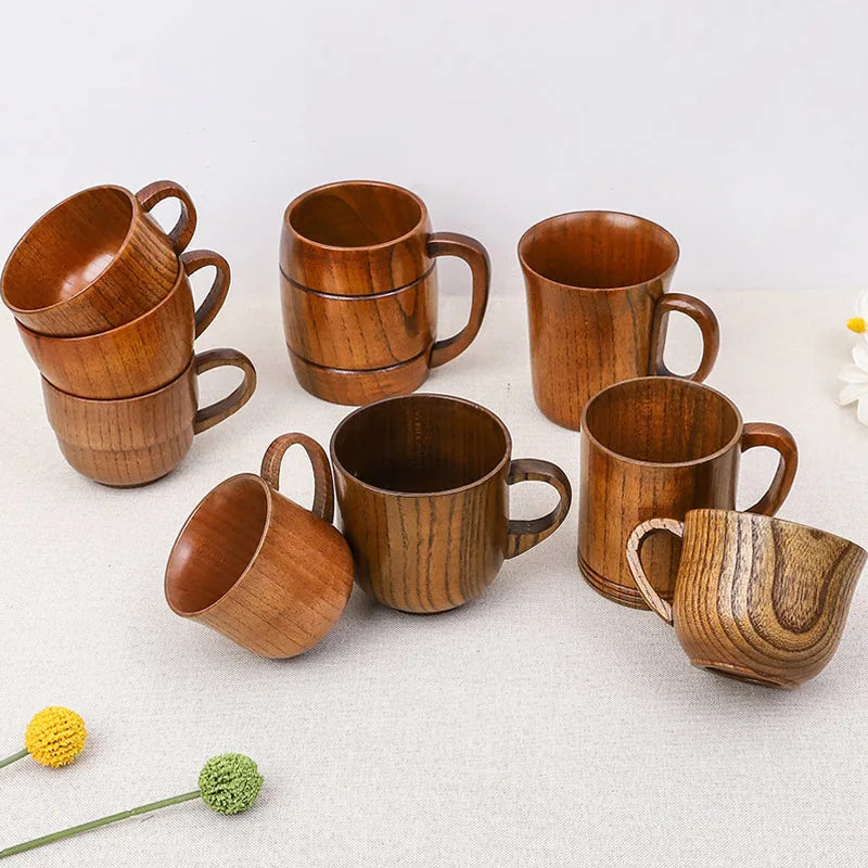 Tasse en bois avec anse, modèle artisanal Nesty, assortiment de tasses en bois empilées et posées sur une nappe beige, avec fleurs séchées