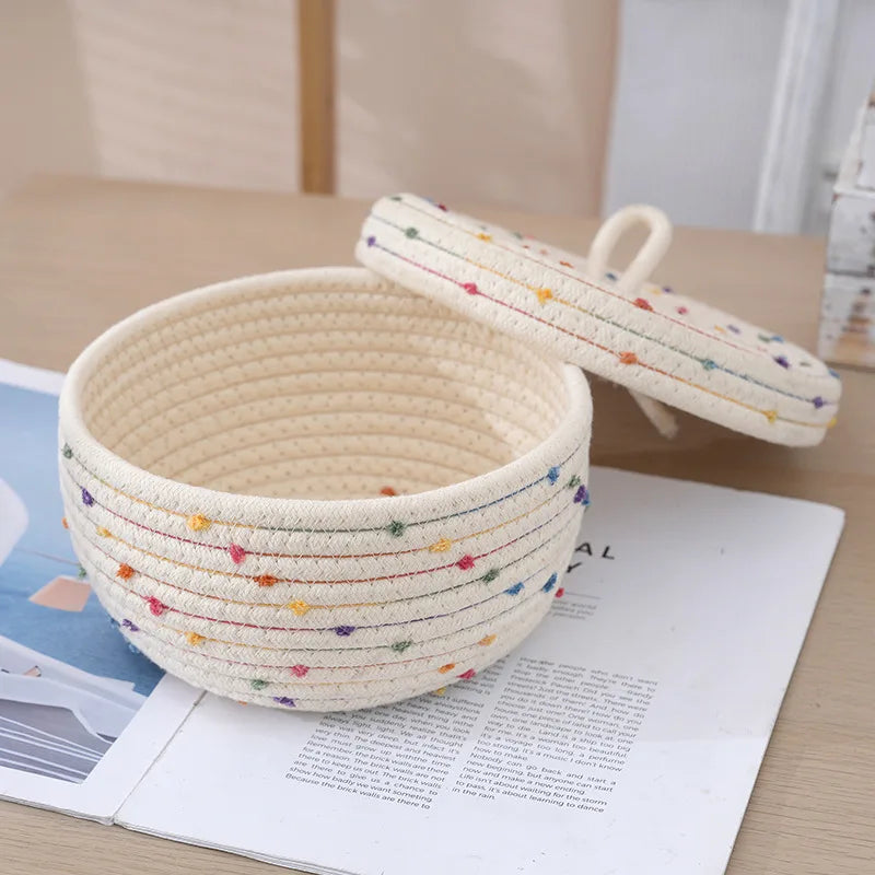 Panier de rangement tressé en corde de coton avec couvercle Nesty, panier ouvert avec couvercle posé à côté, sur un livre ouvert