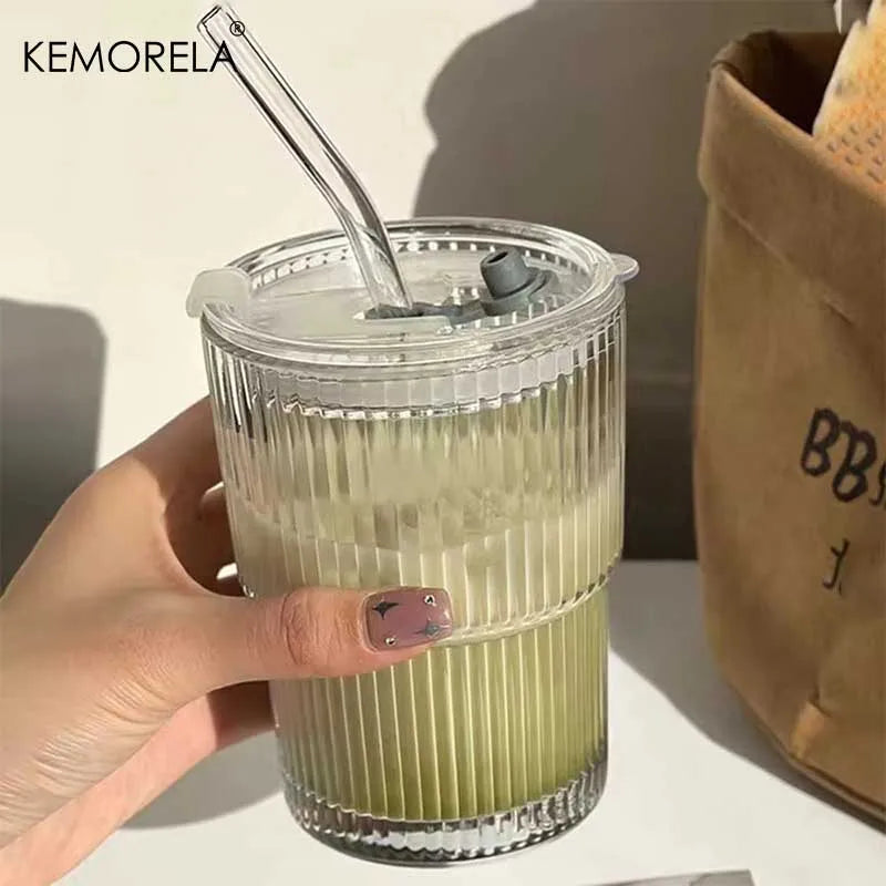 Verre à rayures en verre transparent Nesty - Tenu en main rempli de boisson verte glacée, avec couvercle et paille