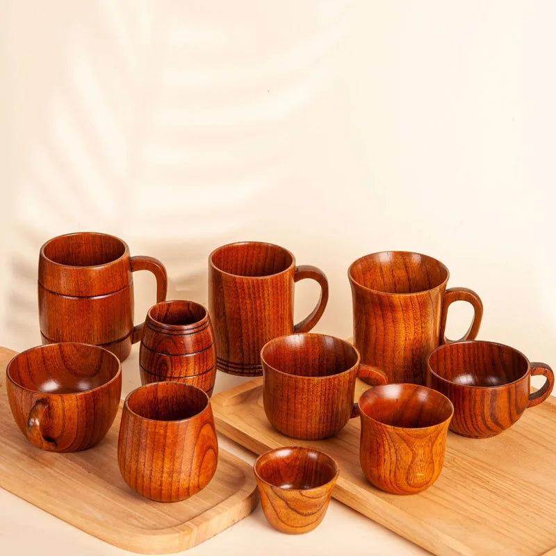 Tasse en bois avec anse, modèle artisanal Nesty, assortiment de tasses et gobelets en bois posés sur des planches à découper