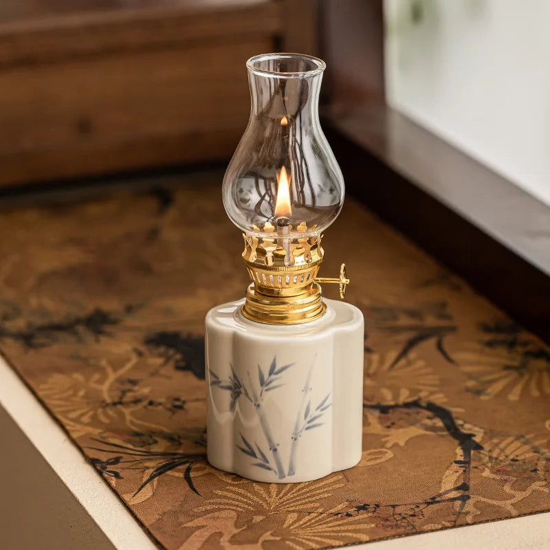 Lampe à pétrole en céramique peinte à la main motif bambou, globe en verre allumé, sur nappe imprimée façon vintage - Nesty
