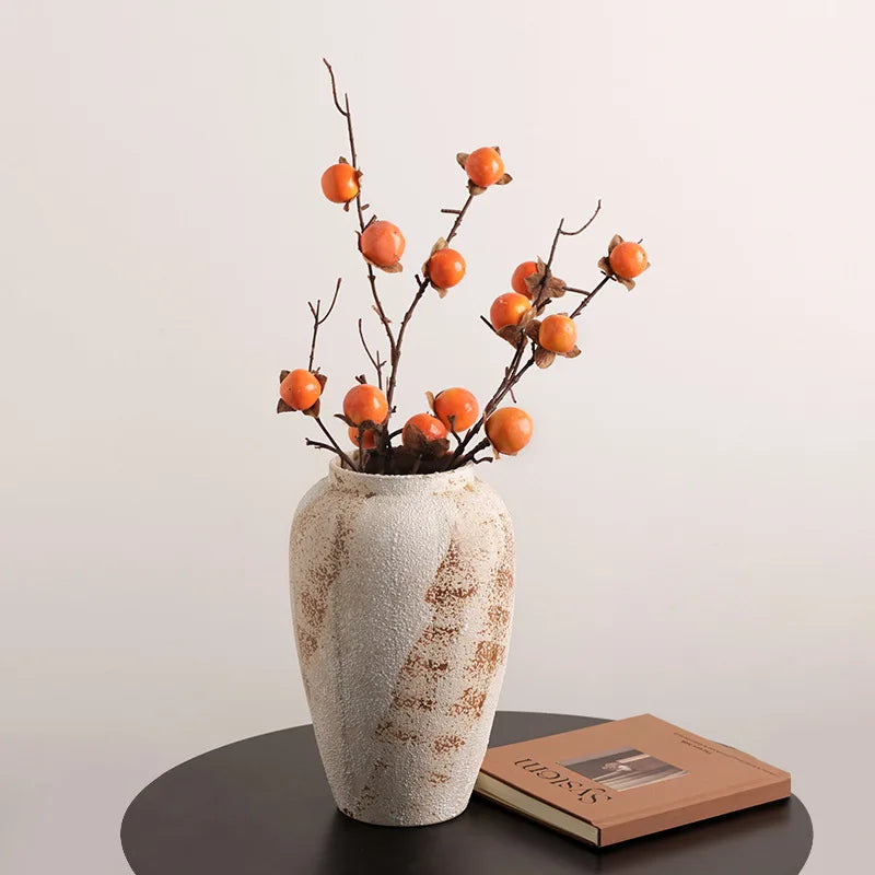 Jarre en céramique artisanale, style wabi-sabi Nesty, format moyen à glaçure tachetée, garni de branches à kakis oranges, sur table ronde avec livre