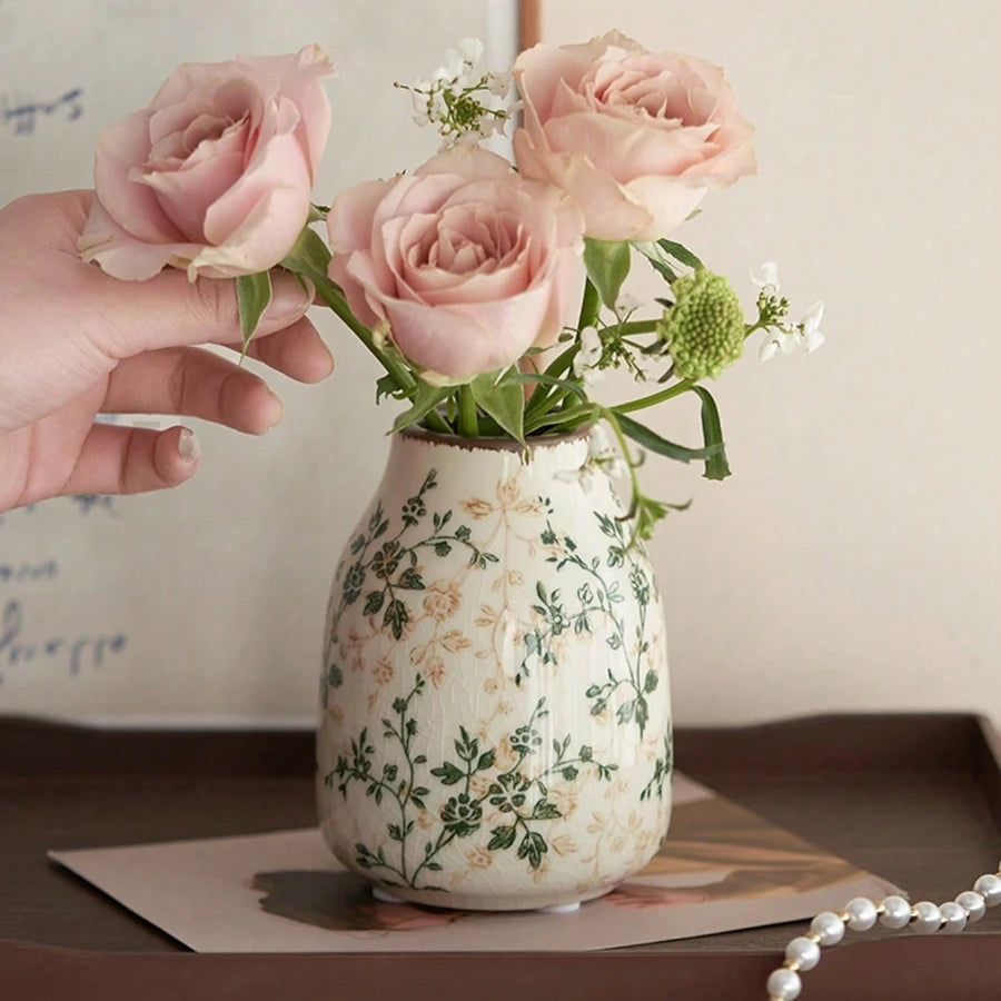 Vase en céramique craquelé, fait main, esprit bohème Nesty, vase craquelé à motif floral vert garni de roses roses, tenu à la main, posé sur un carnet