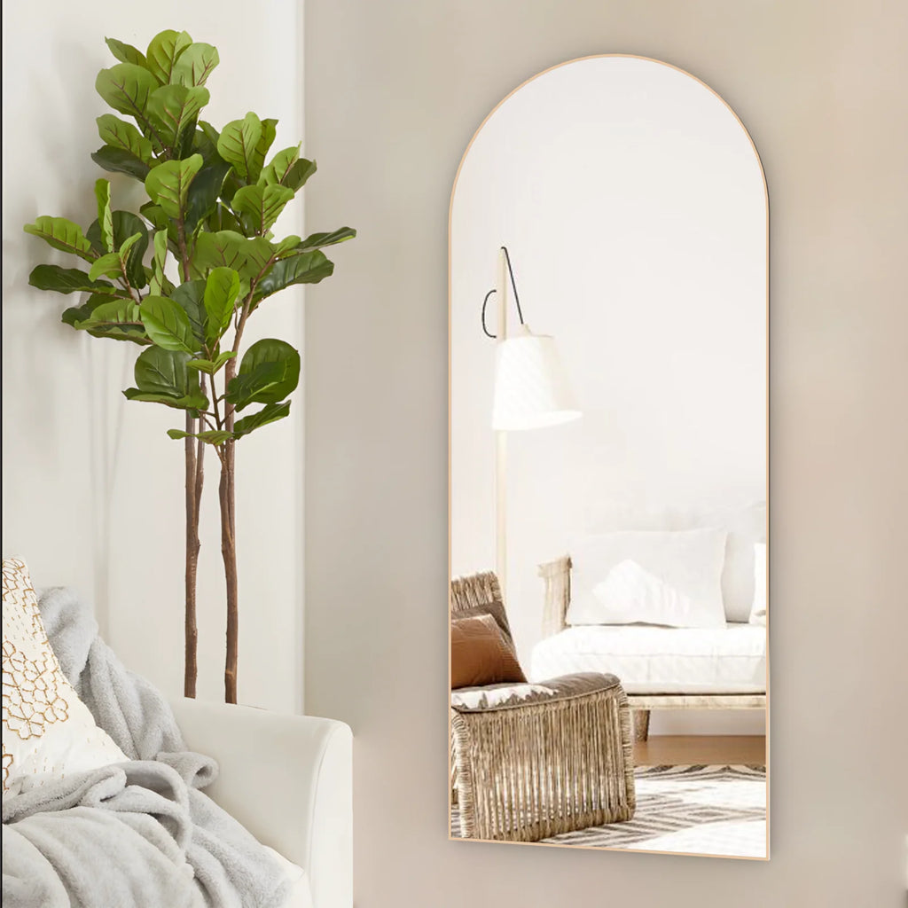 Miroir psyché cintré Nesty - Cadre doré fixé au mur, reflet d'un lampadaire et d'un fauteuil en rotin