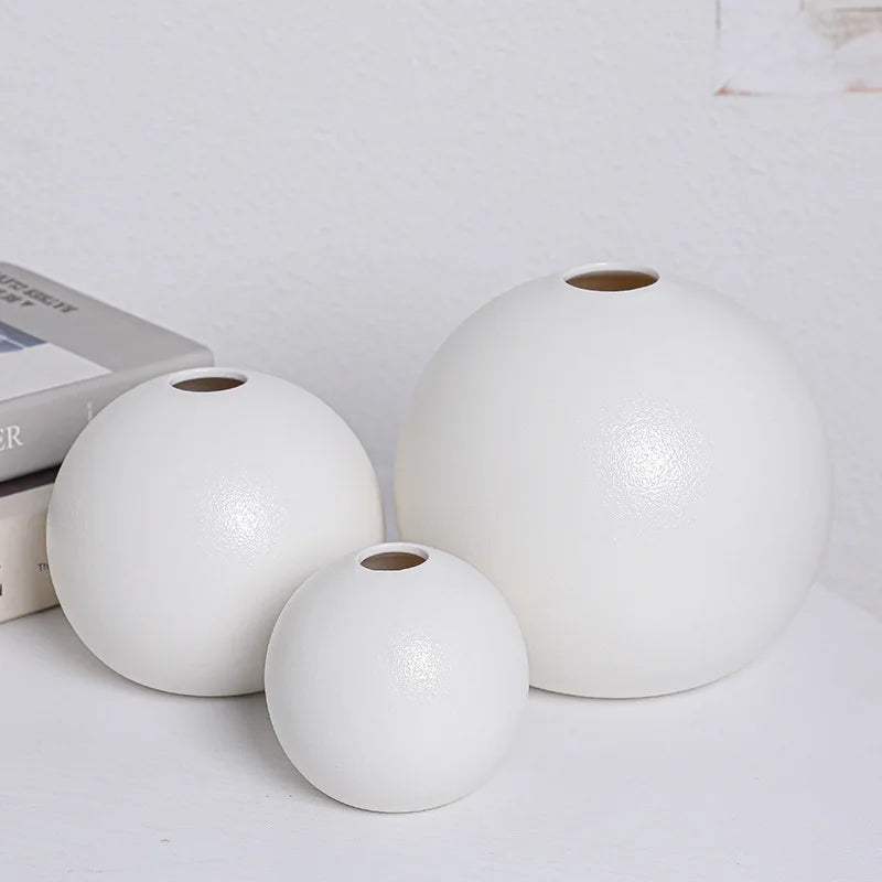 Vase céramique boule bicolore noir et blanc - Nesty - Trois tailles de vase boule blanc mat, posées sur une table près de livres empilés