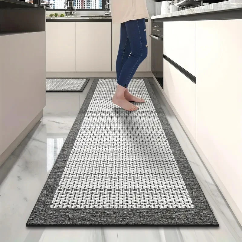 Tapis de cuisine long imitation tissée — antidérapant - Nesty, motif tressé noir et blanc dans une cuisine, avec une personne pieds nus dessus