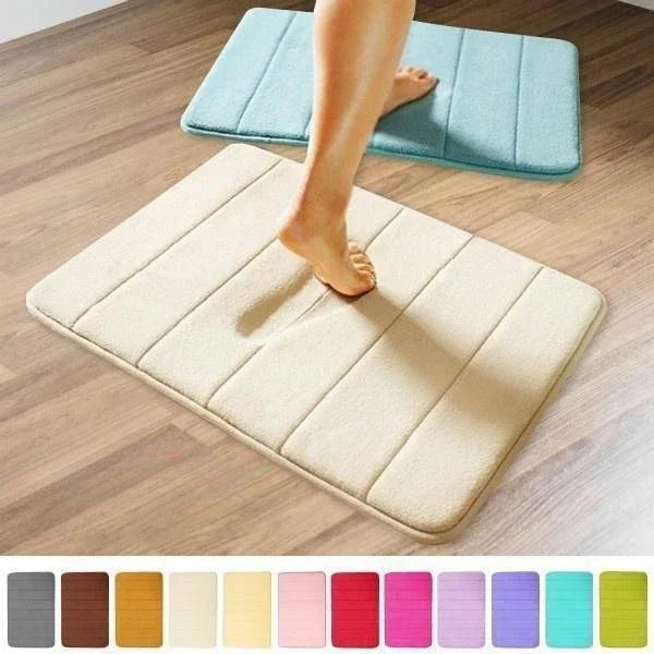 Deux tapis de bain rectangulaires, turquoise et écru, posés sur un parquet avec un pied nu dessus, et un nuancier de couleurs disponibles en bas de l'image.
