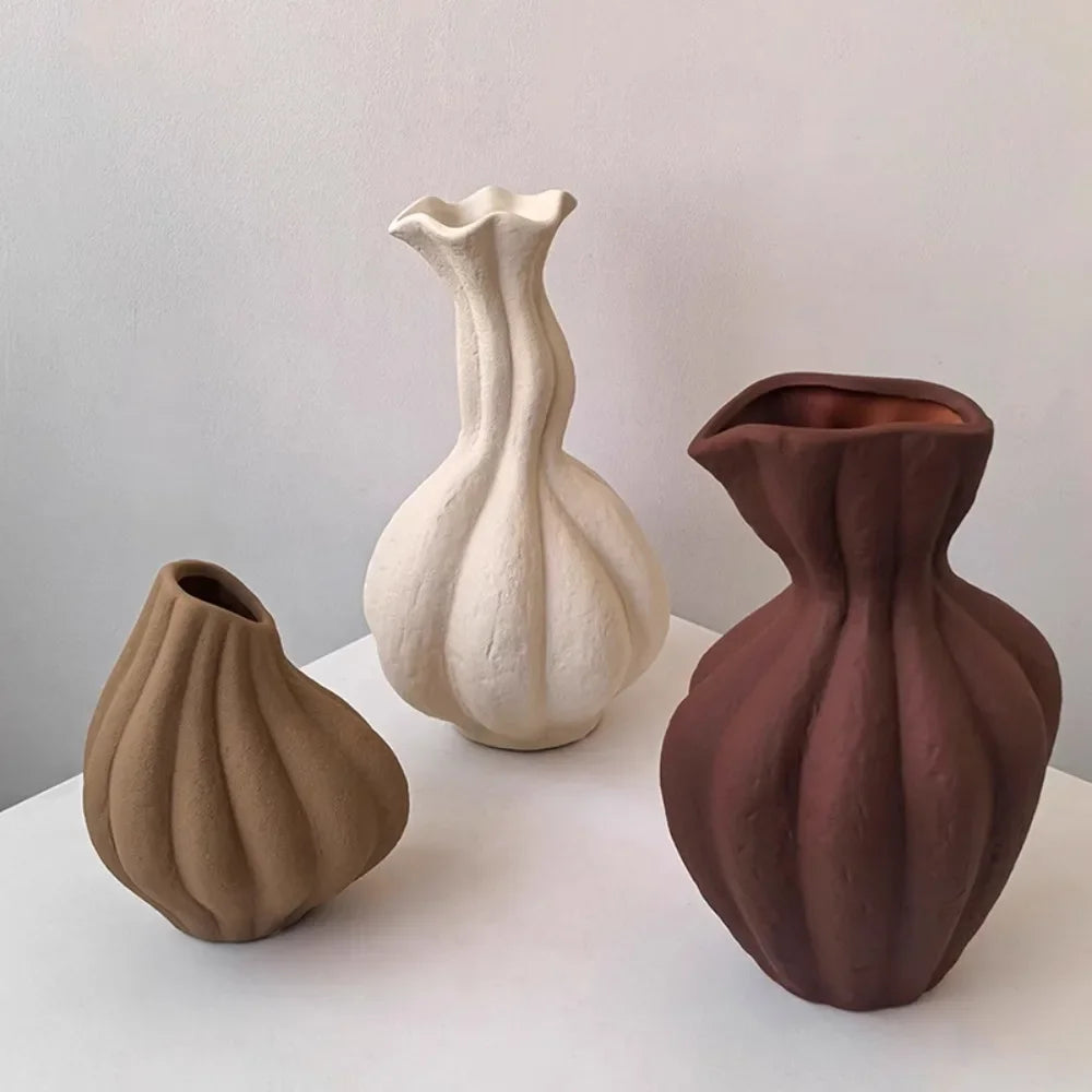 Vase en céramique irrégulier, esprit wabi-sabi, fait main Nesty, trois formes cannelées façon bulbe, camel, blanc cassé et brun bordeaux, sur socle blanc