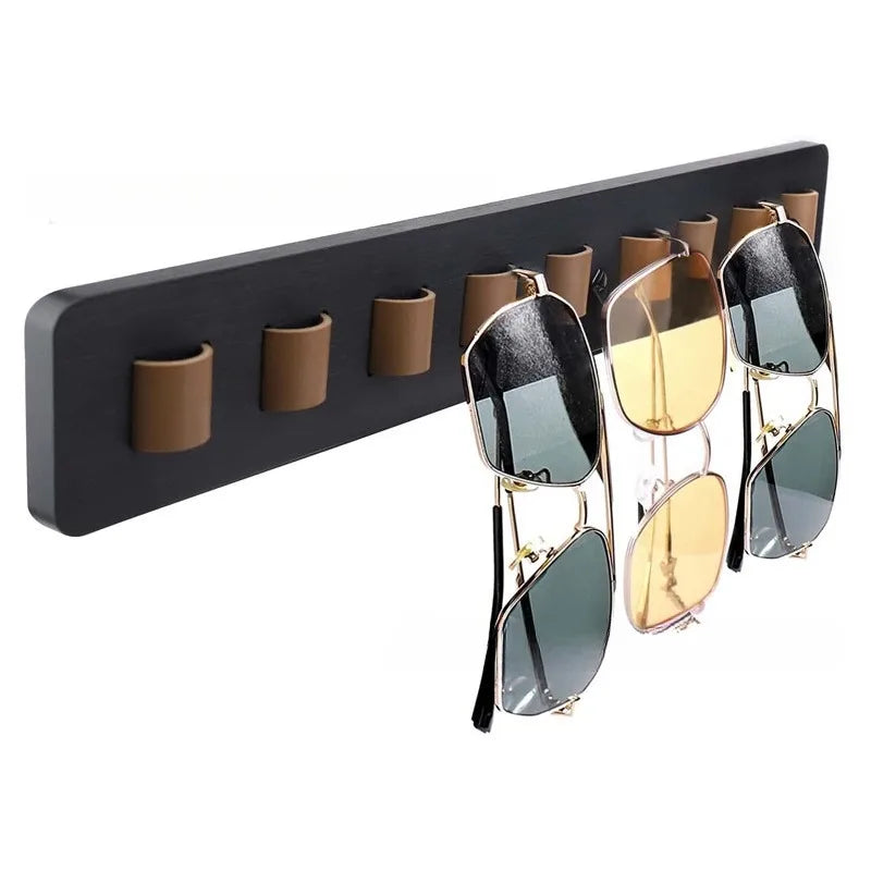 Porte-lunettes mural en bois Nesty, barre murale noire à 8 boucles en cuir marron tenant trois paires de lunettes de soleil