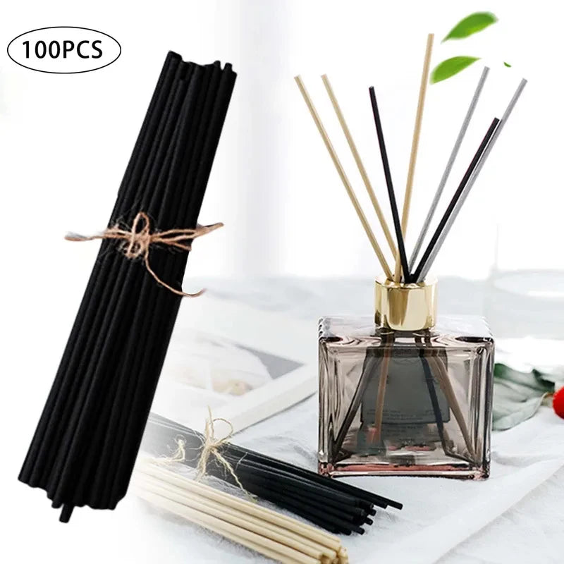 Bâtonnets fins pour diffuseur Nesty - Botte de bâtonnets noirs posée près d'un flacon diffuseur ambré doré