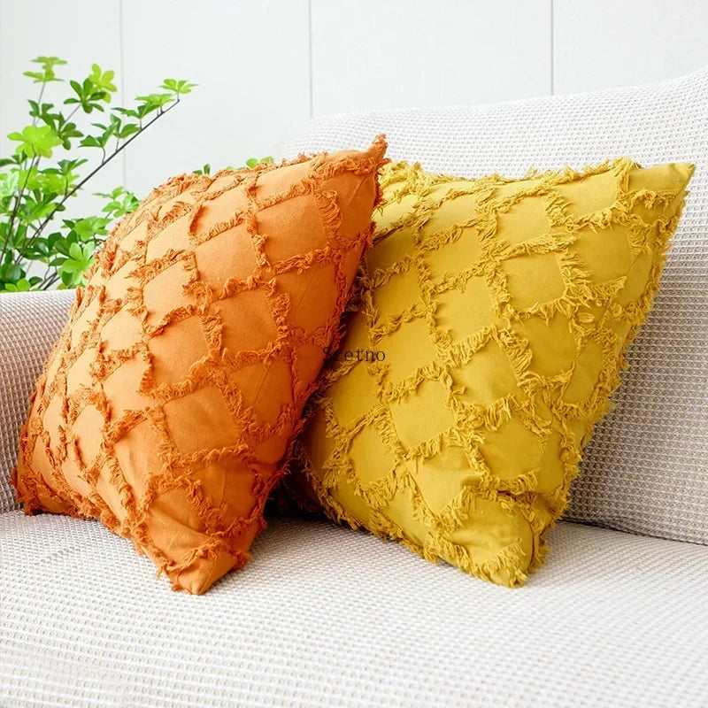 Housse de coussin en coton et lin, motif losange tricoté Nesty, housses de coussin orange et moutarde à texture en losanges effilochés, posées côte à côte sur canapé