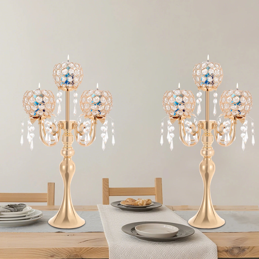 Bougeoir en verre Nesty - Deux candélabres dorés identiques sur une table en bois dressée avec assiettes grises, lot de 2 pièces
