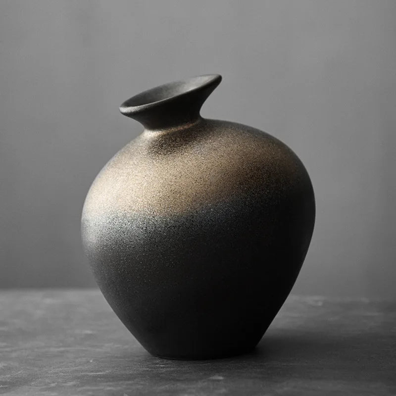 Vase en terre cuite noire, effet pierre brute Nesty, vase rond noir mat à col évasé et dégradé bronze, sur fond gris
