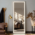 Miroir psyché LED Nesty - Cadre lumineux blanc posé contre le mur dans salon, près d'un lampadaire doré et d'un fauteuil en cuir