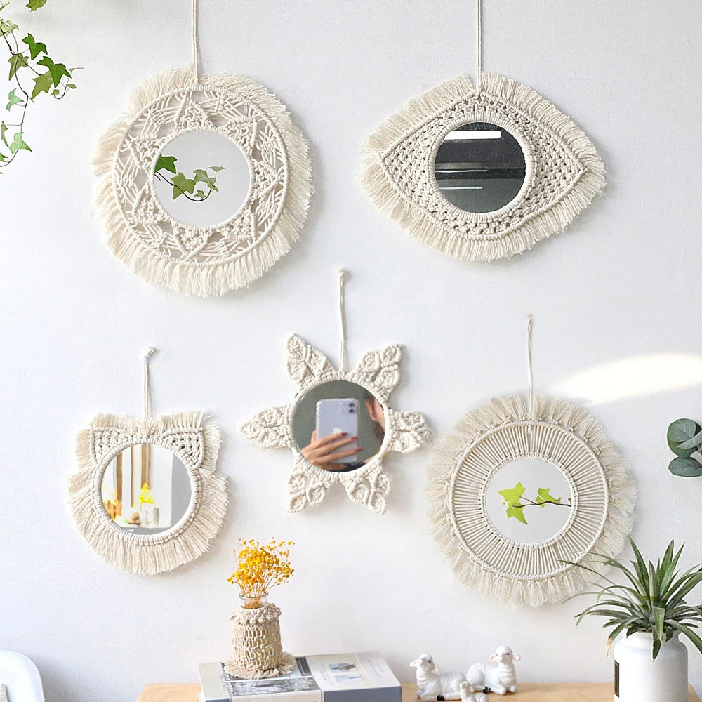 Cinq miroirs muraux macramé aux formes variées (rond, œil, chat, étoile), suspendus sur un mur blanc avec plantes - Nesty