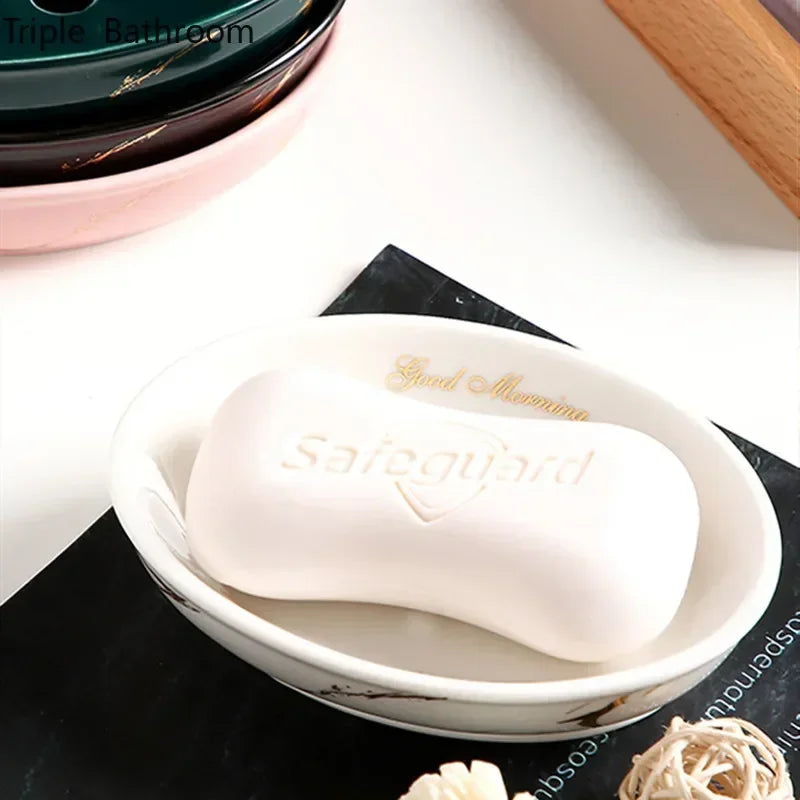 Porte-savon en céramique effet marbré, forme ronde Nesty, coloris blanc garni d'un savon, autres porte-savons empilés en arrière-plan